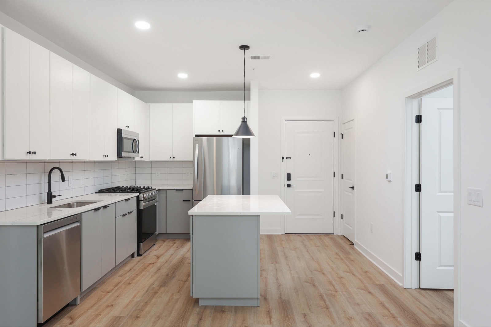 Kitchen with quartz island and stainless appliances in a one-bedroom apartment at The Arthur Carteret NJ
