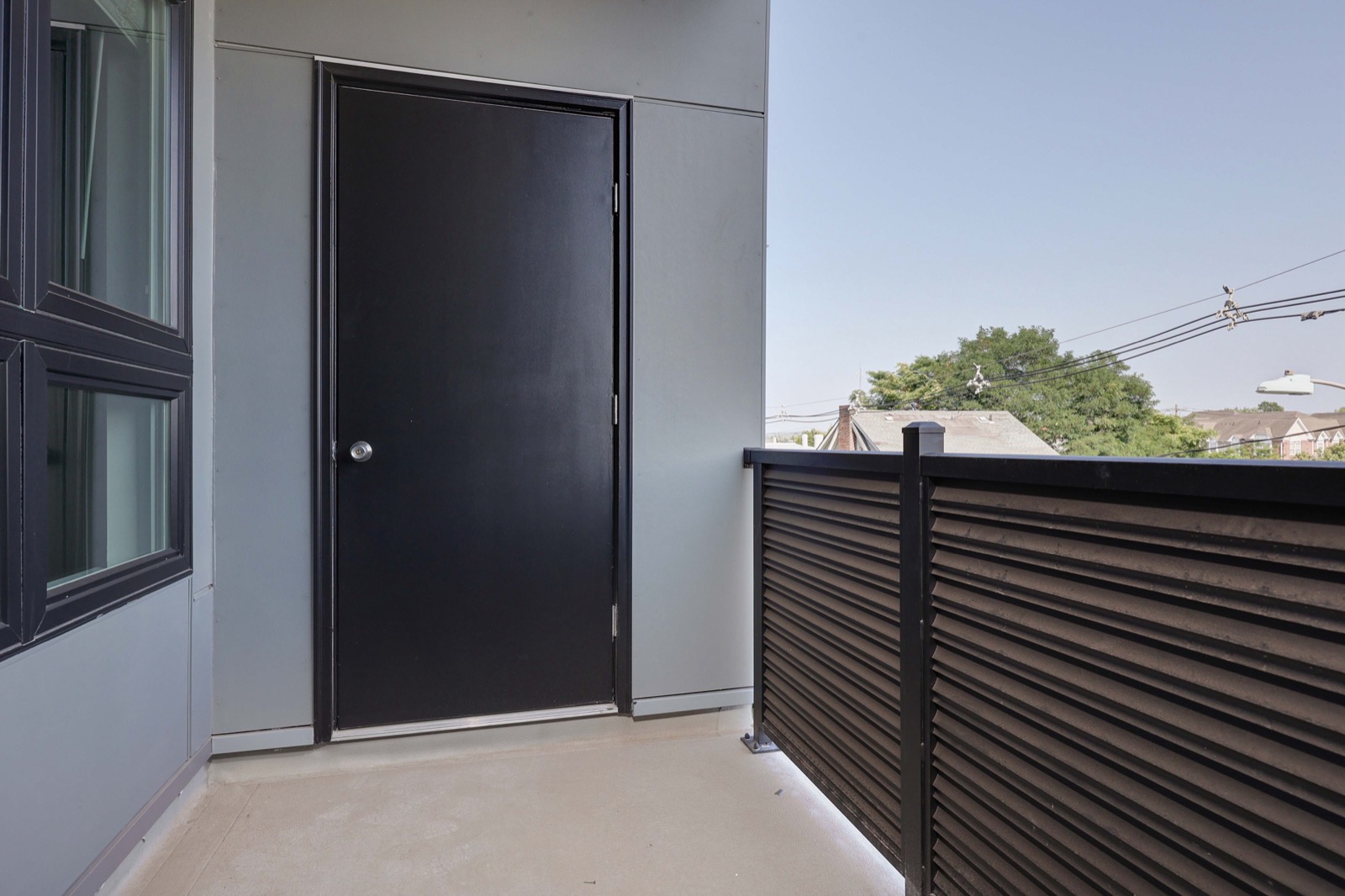 Private patio with wood-slat railing in a two-bedroom apartment at The Arthur Carteret NJ