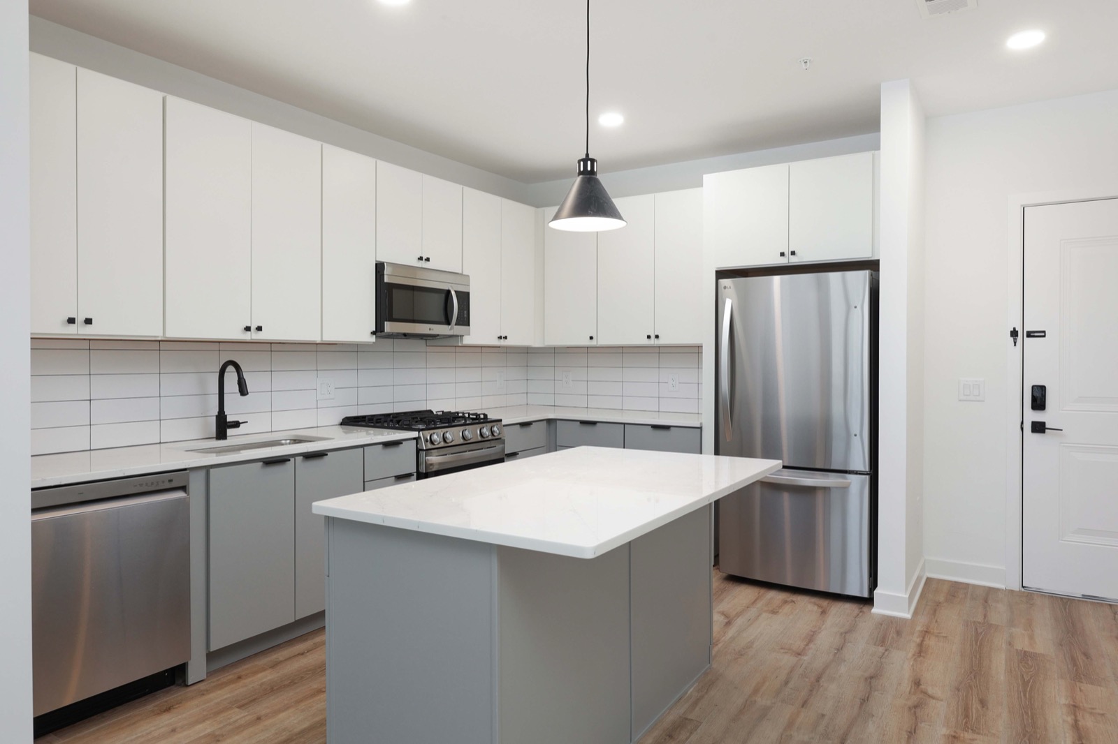 Full kitchen with quartz island and stainless appliances in a two-bedroom apartment at The Arthur Carteret NJ