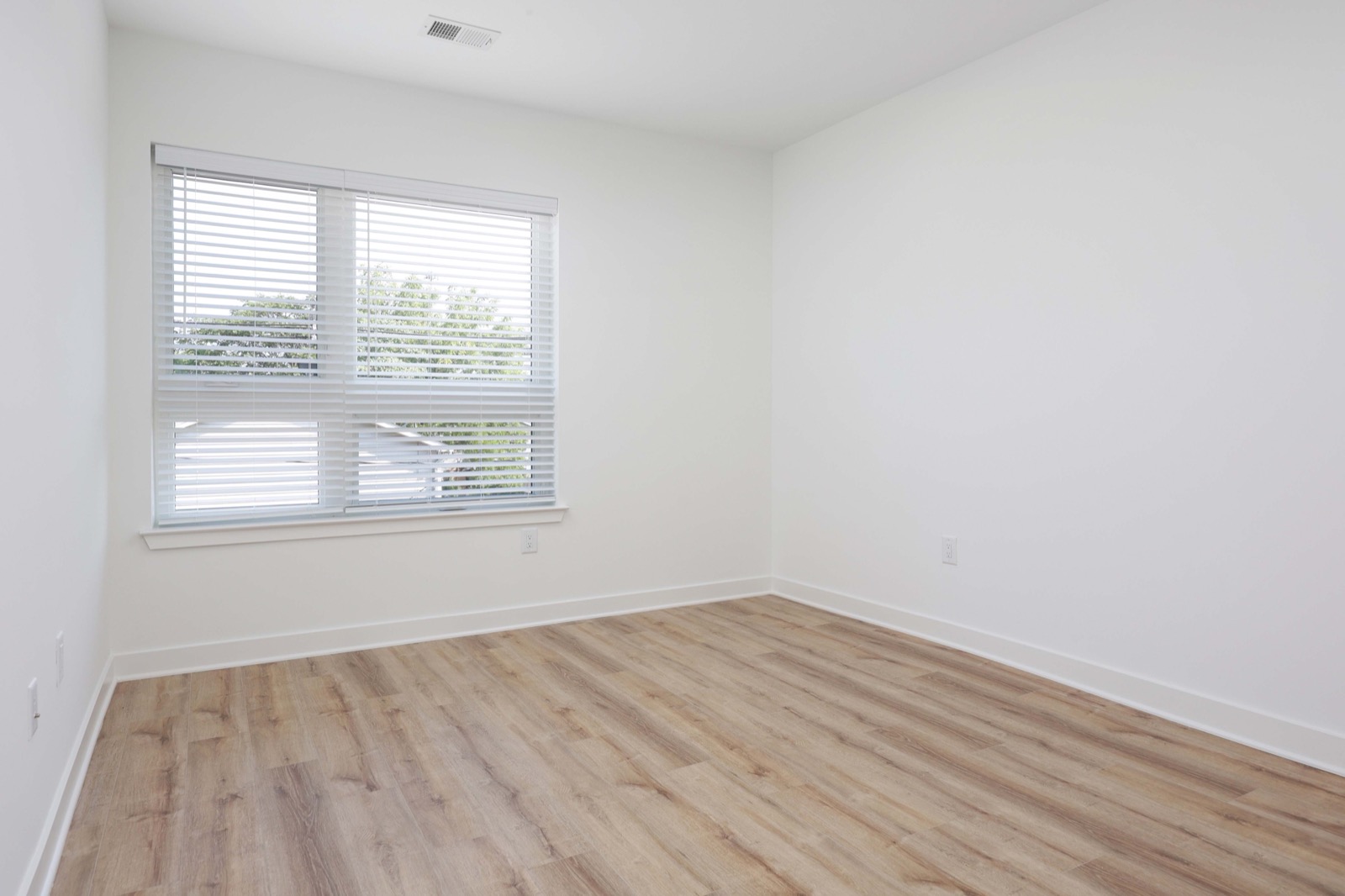Second bedroom with natural light and hardwood floors in a 2BR at The Arthur Carteret